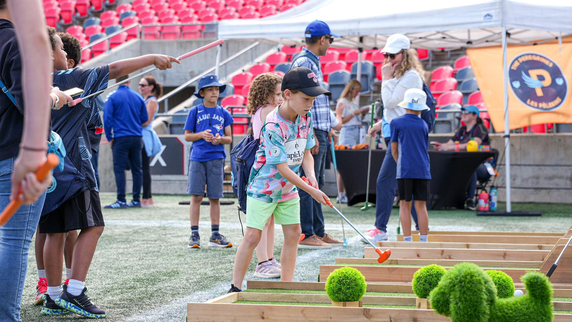 A young boy plays nini golf in the fan zone at an Ottawa Rapid FC game.